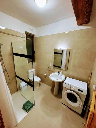 a bathroom with a washing machine and a sink at SeaView Sunset Gozo in Marsalforn