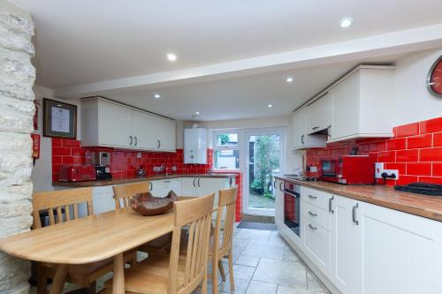 a kitchen with a wooden table and red brick wall at The Crown in Woodstock
