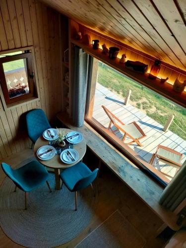 a dining room with a table and chairs and a window at Echo Magura in Măgura