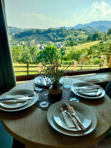a table with plates and utensils on a table with a view at Echo Magura in Măgura