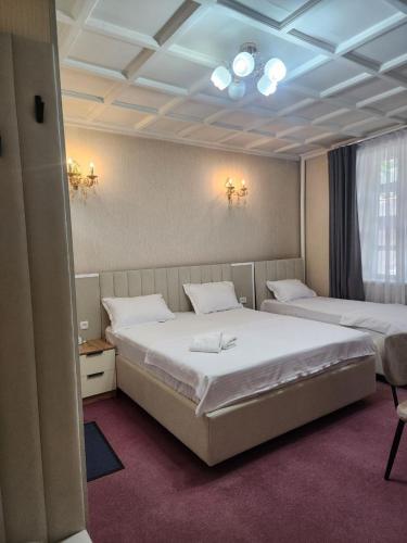 a hotel room with two beds and a window at MIMFRI guest house,hotel in Tashkent