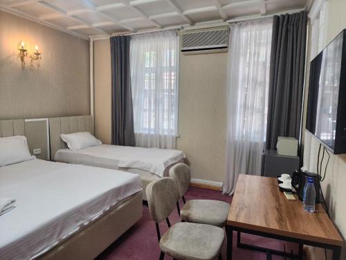 a hotel room with two beds and a table at MIMFRI guest house,hotel in Tashkent