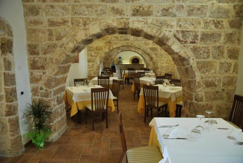 a restaurant with tables and chairs and a brick wall at Masseria Relais Santa Teresa in Sannicola
