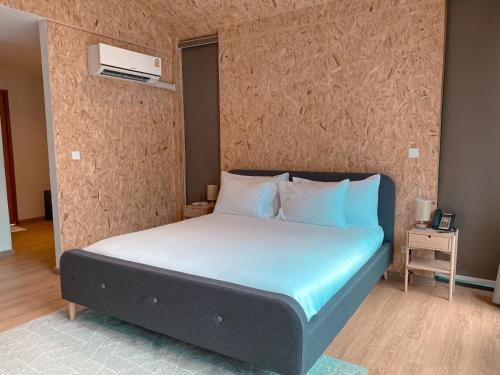 a bedroom with a bed with blue sheets and a wall at The X10 Nordic Tent and Glamping Pool Villa Khaoyai เขาใหญ่ - SHA Certified in Ban Thung Sawang