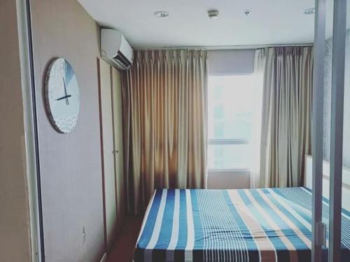 a bedroom with a bed with a blue and white stripes at Studio Seaview Jomtien floor12 23sqm in Jomtien Beach