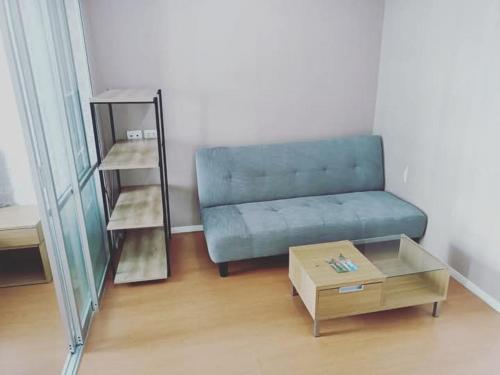a living room with a blue couch and a coffee table at Studio Seaview Jomtien floor12 23sqm in Jomtien Beach
