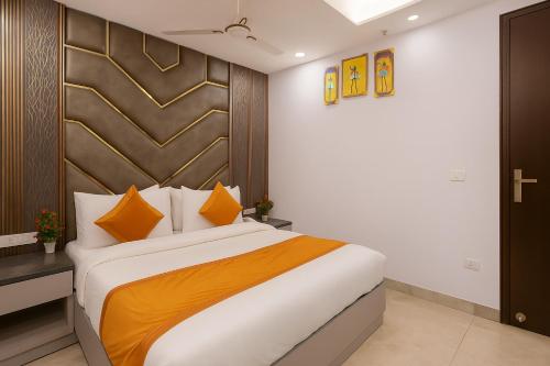 a bedroom with a large bed with orange and white pillows at Hotel Mayfair Just a Minute Away From New Delhi Railway Station and Connaught place in New Delhi