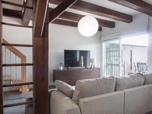 a living room with a couch and a television at Le Jardin Secret, Maison spacieuse et calme in Marlenheim