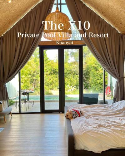 a dog laying on a bed in a room with windows at The X10 Nordic Tent and Glamping Pool Villa Khaoyai เขาใหญ่ - SHA Certified in Ban Thung Sawang