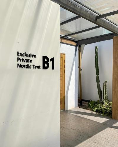a white building with a sign on the side of it at The X10 Nordic Tent and Glamping Pool Villa Khaoyai เขาใหญ่ - SHA Certified in Ban Thung Sawang