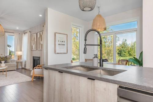 Una cocina con fregadero y una sala de estar. en The Wabi Sabi 4-bedrooms Designer Home, en Kemptville