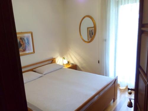 a bedroom with a bed with a mirror and a window at B&B Casa Bazzanella in Cavalese