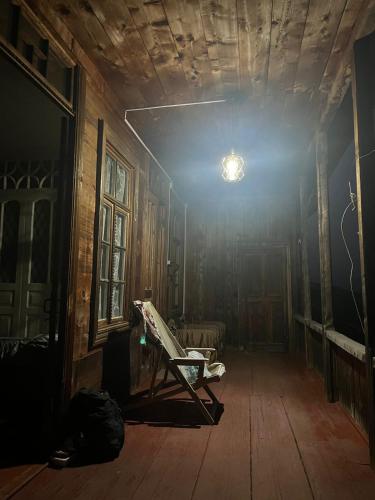 an empty room with a chair in an old house at Chogovadze's Guest House in K'vemo Zhoshkha