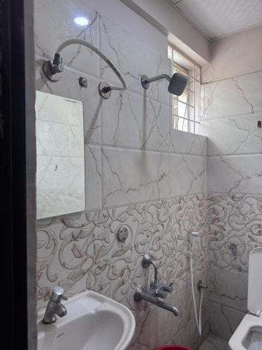 a white bathroom with a sink and a shower at HOTEL GOLDEN Inn in Bengaluru