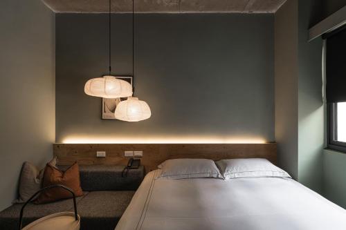 a bedroom with a white bed and two lamps at SI Hotel in Taichung