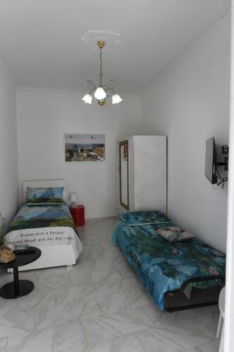 a room with two beds and a table in it at Maison Lepore in Vietri di Potenza