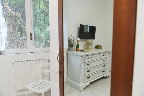 a room with a dresser with a tv and a window at Maison Lepore in Vietri di Potenza