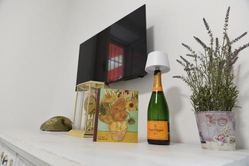 a bottle of wine on a shelf with books and a lamp at Maison Lepore in Vietri di Potenza
