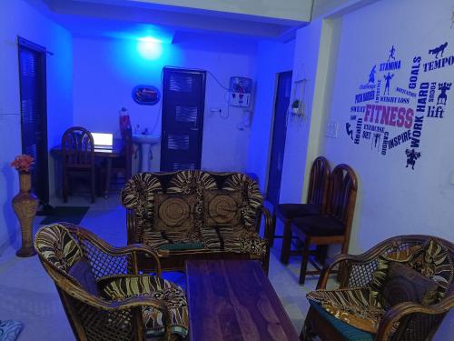 a room with chairs and a table and a couch at May Flower in Patna