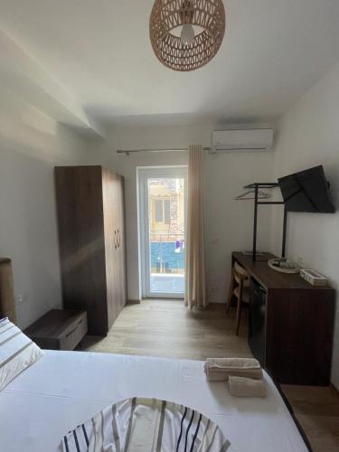 a bedroom with a bed and a desk and a window at Residenza Seliano in Velipojë