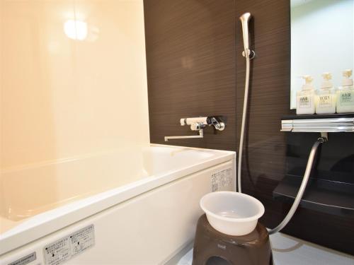 une salle de bain avec baignoire et toilettes dans l'établissement レガリアイン, à Okayama