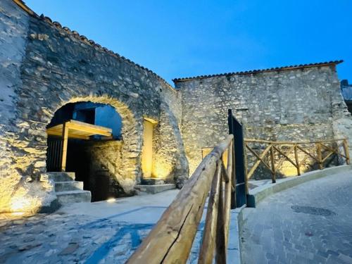 a stone building with a wooden bench in front of it at Maison Lepore in Vietri di Potenza
