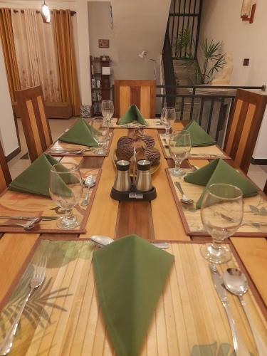 a long wooden table with green napkins and wine glasses at Eco Touch Dickwella in Batigama