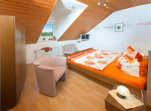 1 dormitorio con 1 cama y 1 silla en una habitación en Pension und Weingut Moselblick, en Brauneberg