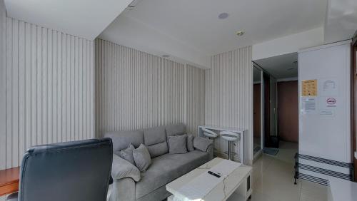 a living room with a couch and a table at Palam Mansion at Meisterstadt Pollux Habibie Apartment in Batam Center