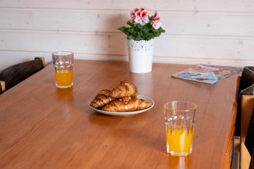 a table with a bowl of food and two glasses of orange juice at Domki Primore in Władysławowo