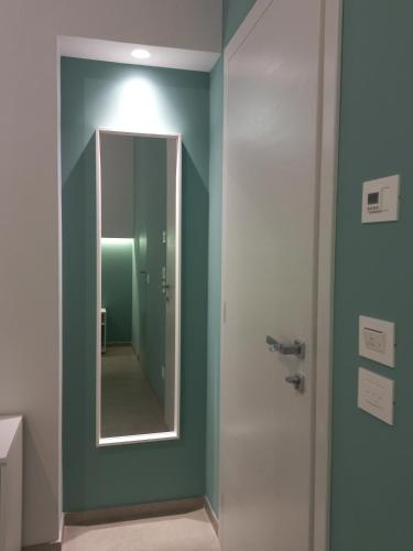 a bathroom with a mirror and a green wall at L'Altalena Guest House in Lido Di Fondi
