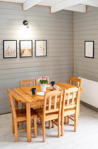 a wooden table and chairs in a room at Domki Primore in Władysławowo