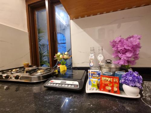 a kitchen counter with a stove and some flowers at 3Bhk Villa with Swimming Pool I Nyra Homestay in Jaipur