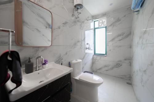 a white bathroom with a sink and a toilet at 3Bhk Villa with Swimming Pool I Nyra Homestay in Jaipur