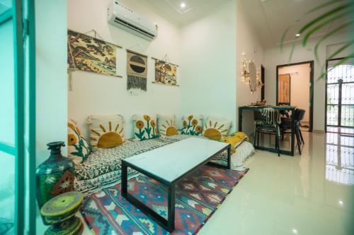 a living room with a table and a couch at 3Bhk Villa with Swimming Pool I Nyra Homestay in Jaipur