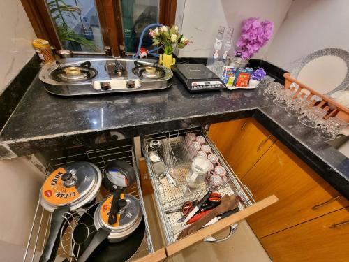 a kitchen counter with a sink with dishes and a sink at 3Bhk Villa with Swimming Pool I Nyra Homestay in Jaipur