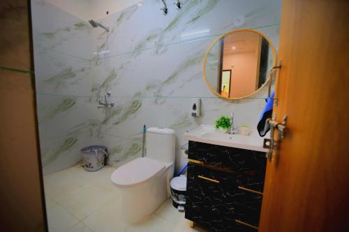 a bathroom with a toilet and a sink and a mirror at 3Bhk Villa with Swimming Pool I Nyra Homestay in Jaipur