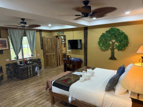 a bedroom with a bed with a tree on the wall at On The Mekong Resort in Luang Prabang