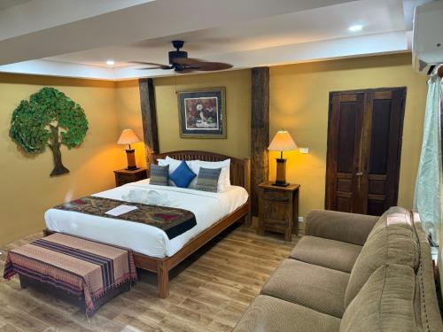 a bedroom with a bed and a couch at On The Mekong Resort in Luang Prabang