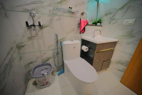 a bathroom with a white toilet and a sink at 3Bhk Villa with Swimming Pool I Nyra Homestay in Jaipur