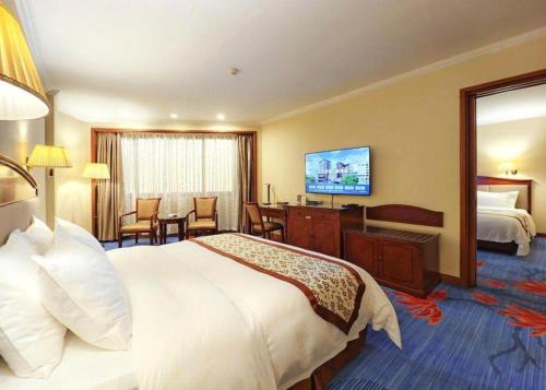 a hotel room with a large bed and a television at Quanzhou Hotel in Quanzhou