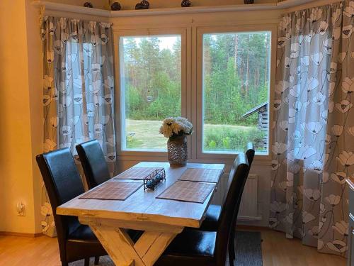 einen Tisch mit einer Vase darüber neben einem Fenster in der Unterkunft Ullavan pieni helmi in Kokkola