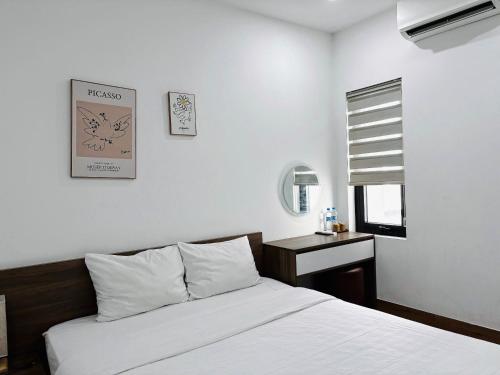 a bedroom with a bed and a table and a clock at Lamour homestay in Thôn Kim Long (1)