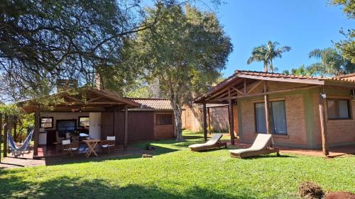 una casa con un patio con sillas y una mesa en Cabañas lodge El Suizo, en Gobernador Virasora