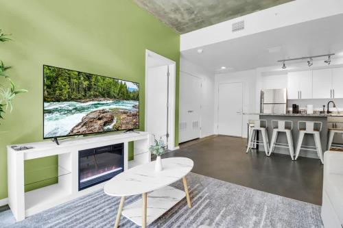 a living room with a large flat screen tv on a wall at Centric 2BR In HEART of DTPHX Free Garage Parking in Phoenix