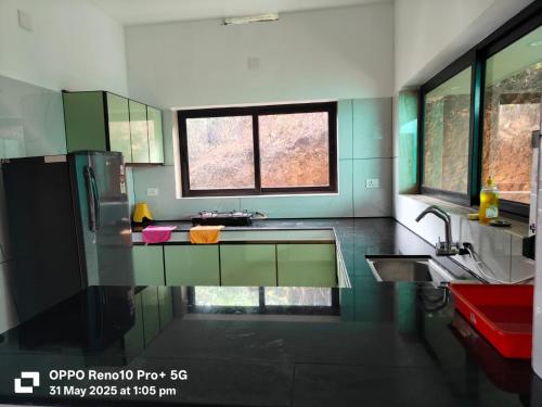 una cocina verde y blanca con fregadero y ventana en Magic Destination, en Vagamon