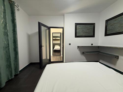 ein weißes Schlafzimmer mit einem Bett und einem Spiegel in der Unterkunft Sax Camping Costinesti in Costinești