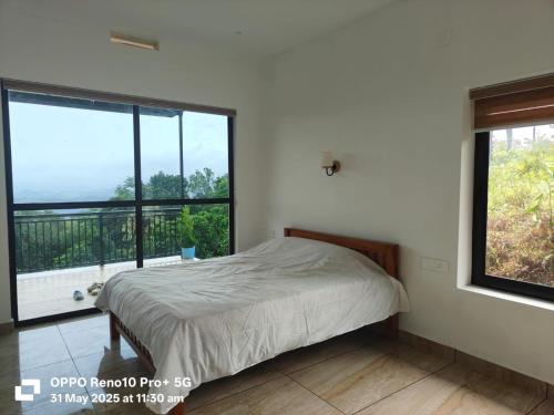 Un dormitorio con una cama y una ventana grande en Magic Destination, en Vagamon