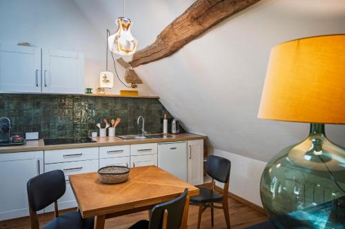a kitchen with a table and chairs and a lamp at Maison le Village - Maison d’Hôtes in Montagny-lès-Beaune