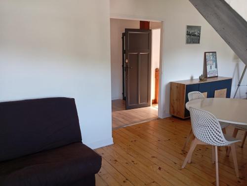 a living room with a table and a chair at Appartement renové 46m2 - Climatisé, Calme et proche commodités in Tulle